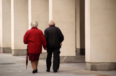 Sokakta yürüyen yaşlı insanlar.
