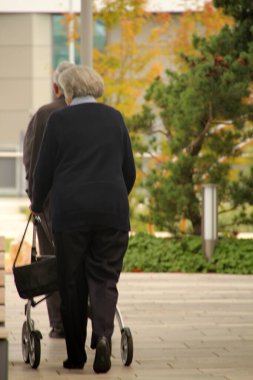 Sokakta yürüyen yaşlı insanlar.