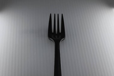 Gri arkaplanda plastik çatal