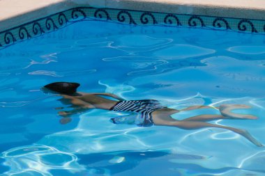 Çocuk yaz gününde yüzüyor.