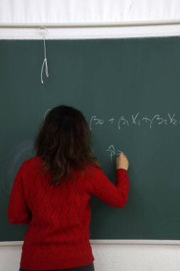 Öğretmen tahtaya yazı yazıyor.