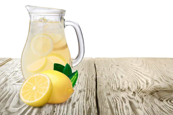Jarro ou jarro de limonada com limões em primeiro plano em pé — Fotografia de Stock