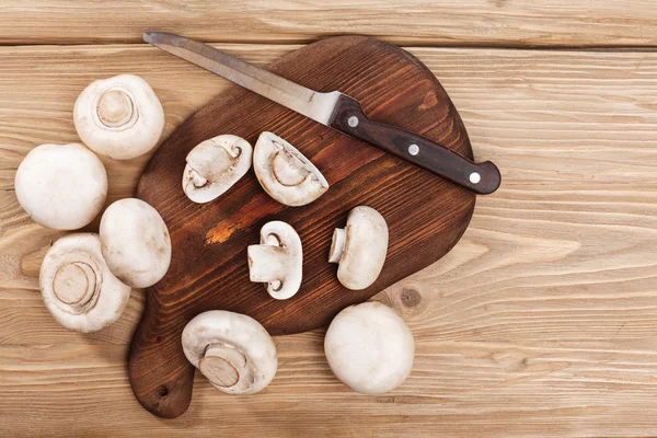 Cogumelos frescos em tábua de madeira — Fotografia de Stock