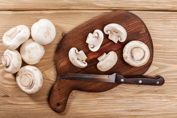 Champignons frais sur planche à découper en bois — Photo