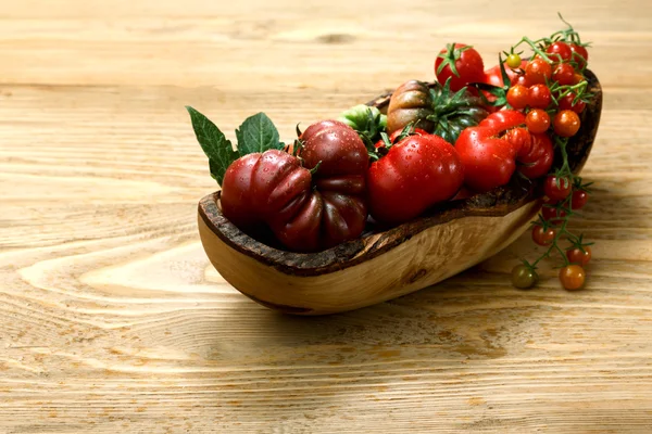 Tomates de relíquia frescos em mesa de madeira — Fotografia de Stock