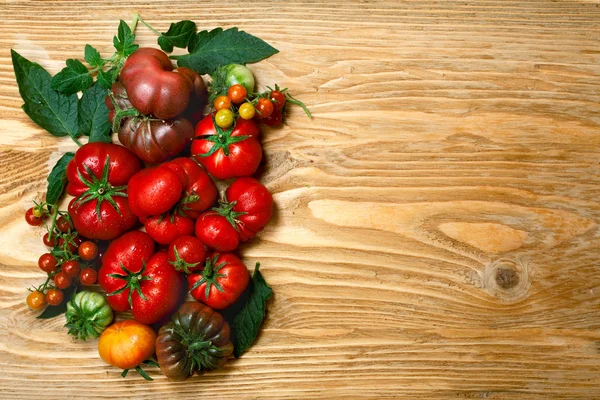 Tomates de relíquia frescos em mesa de madeira — Fotografia de Stock