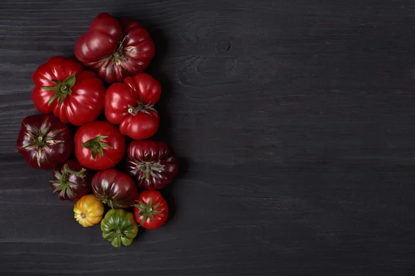 Tomates reliquia en tablero negro de madera —  Fotos de Stock