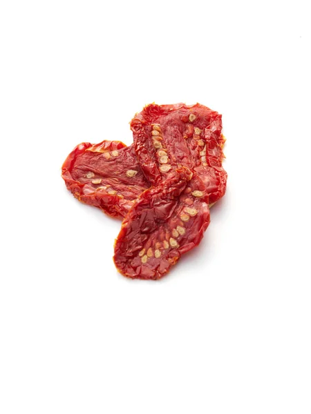 Güneşte kurutulmuş domatesler beyazın üzerinde.