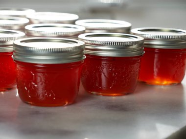 Kırmızı biberli jöle konservesi bitti. Dolu kavanozları güneş ışığında muhafaza ediyor.
