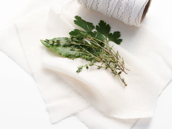 Bir buket garni baharat karışımı için geleneksel malzemeler körfez yaprağı, kısmen ve kekik peynirli bezle sarmaya hazır..