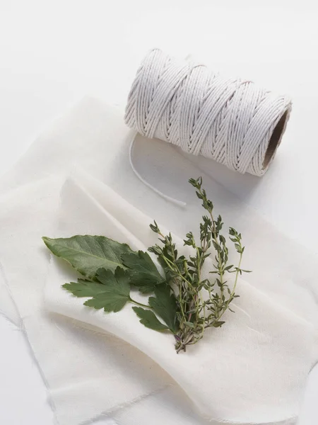 Bir buket garni baharat karışımı için geleneksel malzemeler körfez yaprağı, kısmen ve kekik peynirli bezle sarmaya hazır..