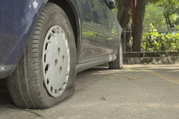 Abbandonare auto blu nel parcheggio con pneumatici a terra — Foto Stock