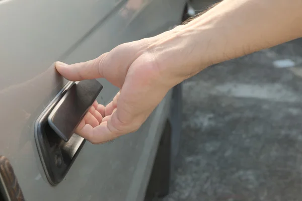 Maschio mano apertura porta auto dall'esterno tirando maniglia porta in plastica nera — Foto Stock