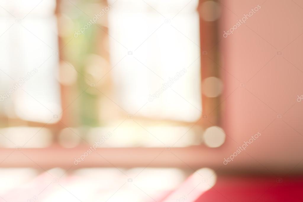 Abstract blurry red monk seat near large window