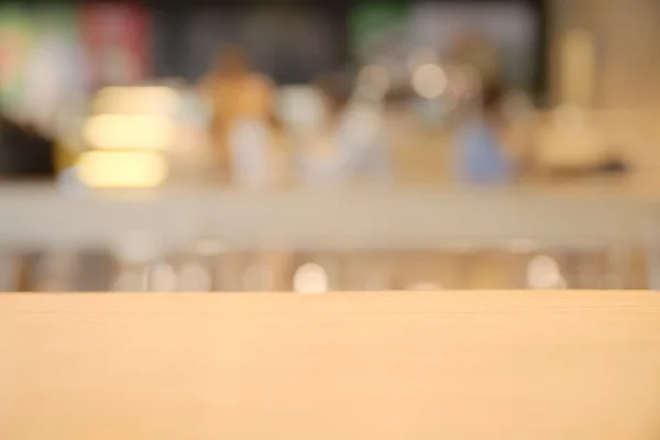 Abstract blurry coffee shop counter with wooden table in foreground background — Stock Photo, Image