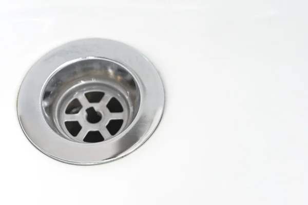 Fechar o dreno de aço inoxidável de fundo lavatório branco Imagem De Stock