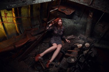 Kızıl saçlı kız, paslı bir teknede, aç. 