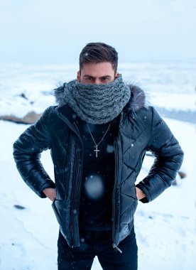 Kışın arka planda siyah elbiseli bir adam.
