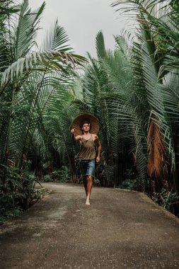 Tropik bölgelerde hasır şapkalı bir adam.