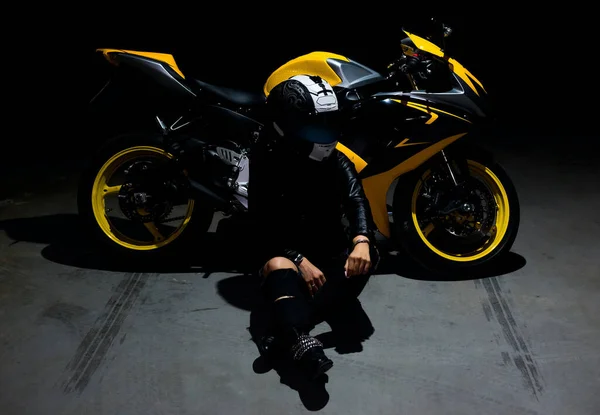 Jonge aantrekkelijke vrouw zitten met haar motorfiets en helm. — Stockfoto