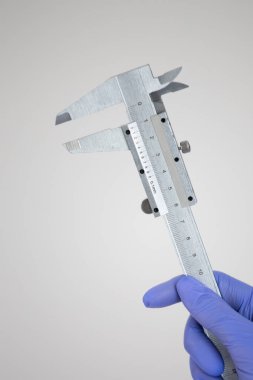 Diş hekimi, kalibre, eldiven tutan kız için tıbbi aletler.