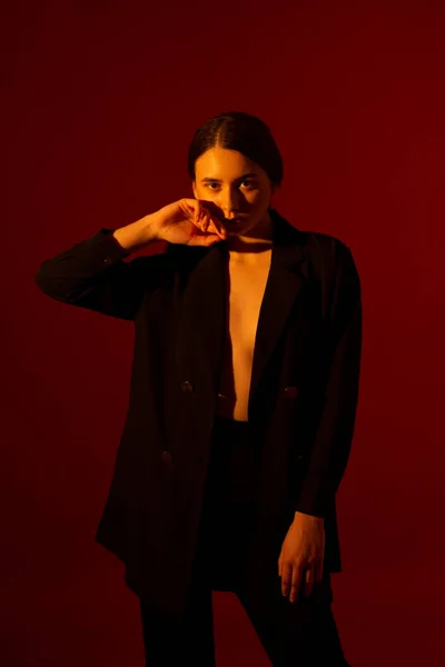 Chica con chaqueta negra sobre fondo rojo —  Fotos de Stock
