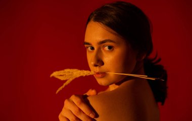 Kırmızı arka planda bir buket ölü tahtası olan bir kız.