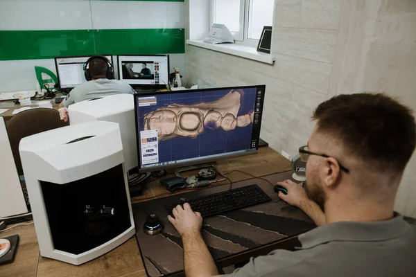 Protez ve taçlandırma için modern bir diş laboratuvarında dişçi destekli bir makine.