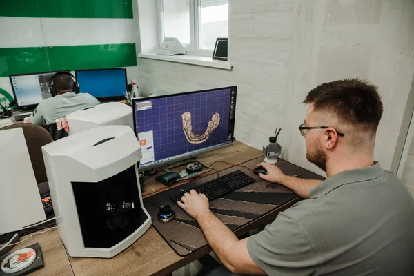  Protez ve taçlandırma için modern bir diş laboratuvarında dişçi destekli bir makine.