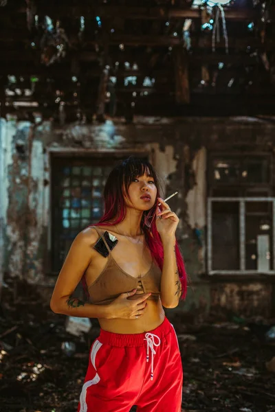 Dívka kráčí ulicí, kouří cigaretu, s obarvenými vlasy — Stock fotografie