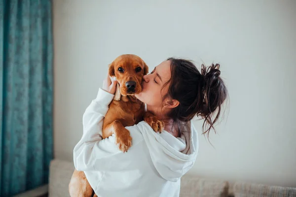 Uma menina de capuz branco beija um cachorro — Fotografia de Stock