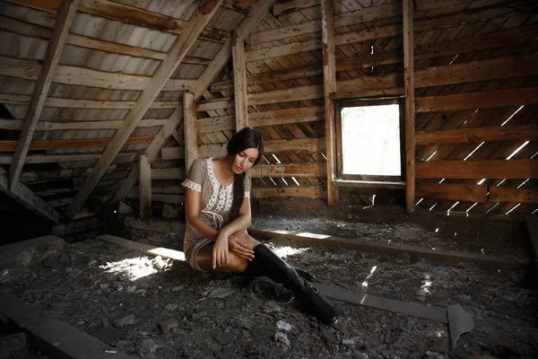 Triste fille assise dans une maison abandonnée, dans le grenier, vêtue de style rétro — Photo