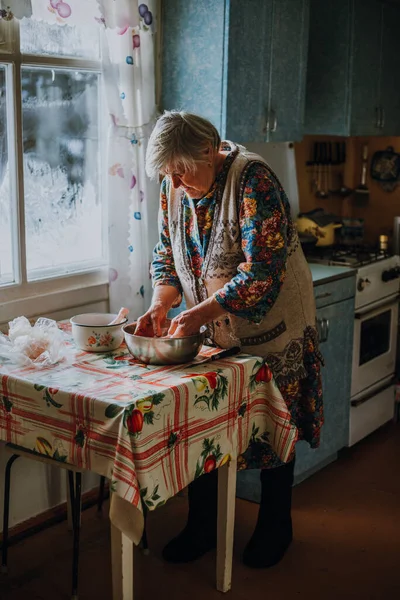 Русская бабушка режет курицу голыми руками — стоковое фото