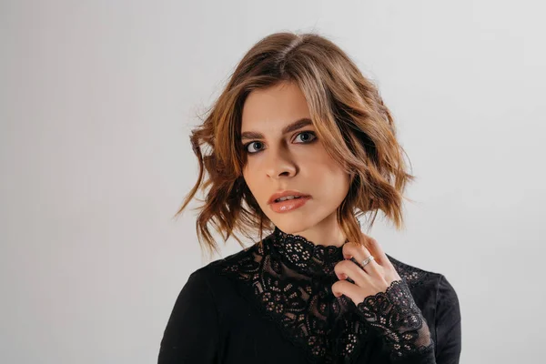 Retrato de uma mulher morena em um corte de cabelo de estúdio de fotos sob um quadrado — Fotografia de Stock