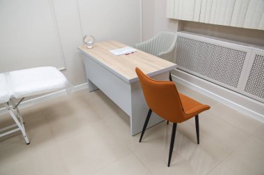 Kozmetik ofisinin modern iç mimarisi. Tam elektrikli yüz güzelliği yatağı ve sandalyesi ve güzellik salonunda cilt ürünleriyle dolu rafları var..