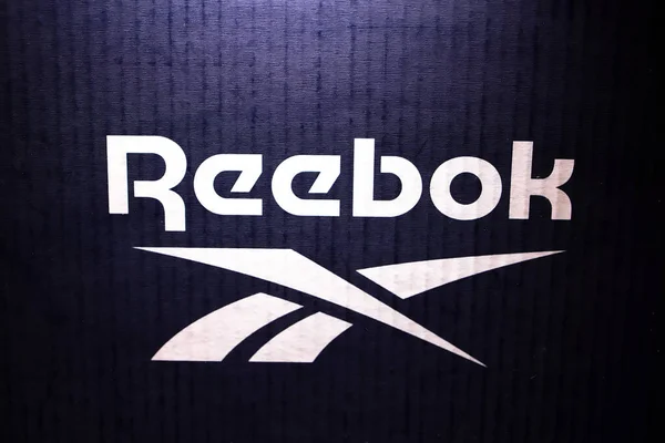 Logo Reebok, na niebieskim tle w neonowym świetle — Zdjęcie stockowe