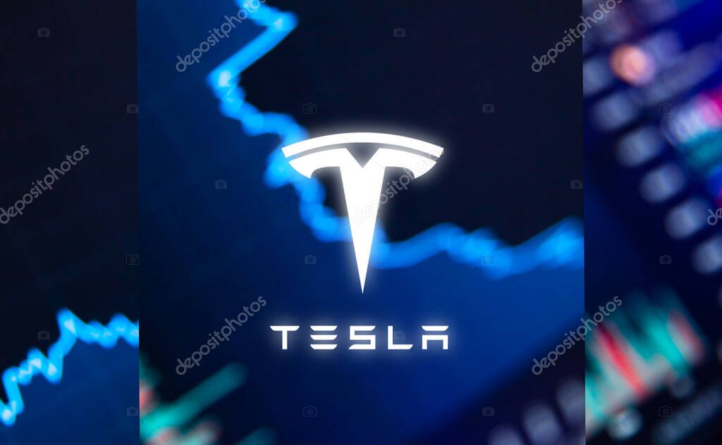 The Tesla logo on the background of the growth of the companys shares. High quality photo