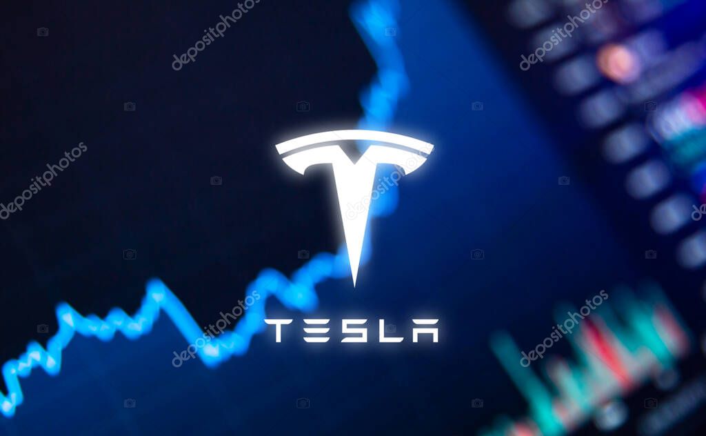The Tesla logo on the background of the growth of the companys shares. High quality photo