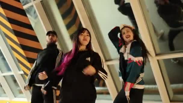 Νέοι άνδρες και γυναίκες χορεύουν με adidas ρούχα στην κάμερα — Αρχείο Βίντεο
