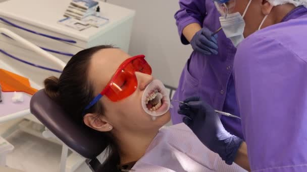 Installation d'appareils orthopédiques chez l'orthodontiste, dentisterie, vérification du médecin dans les gants — Video