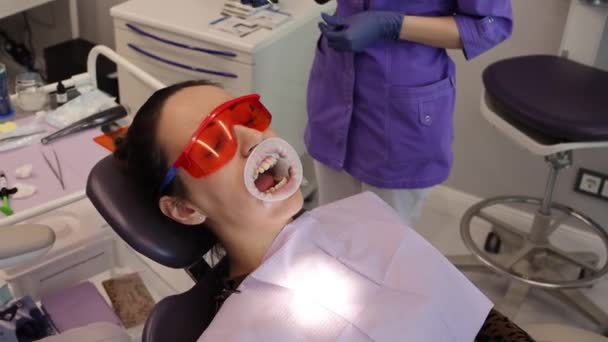 Dentist appointment Ortadont, installation of braces on teeth, patient on the couch — Stock Video