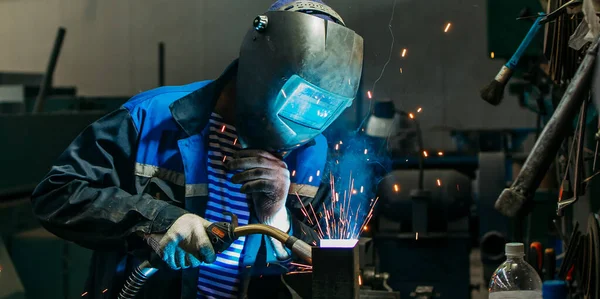 Kaynakçı yarı otomatik kaynak makinesinde elektrot ile çalışıyor..