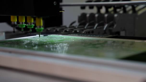 Een robotmachine produceert elektronische printplaten in close-up. De machine print het digitale bord, contract productie. Productie van elektronische microchips. Robotarm — Stockvideo