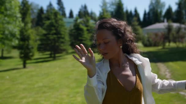 Una chica baila misteriosamente en un parque en la naturaleza en una capa blanca — Vídeos de Stock