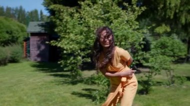 Neşeli bir kadın doğada yürümekten zevk alır çimenlerde koşar ve güler.