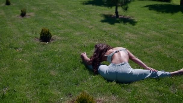 Ejercicios de estiramiento para todo el cuerpo por la mañana en la naturaleza, una chica yogui practica ejercicios para la longevidad — Vídeo de stock