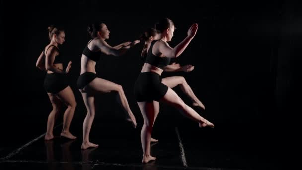 Cuatro mujeres en ropa negra bailan sobre un fondo aislado — Vídeos de Stock