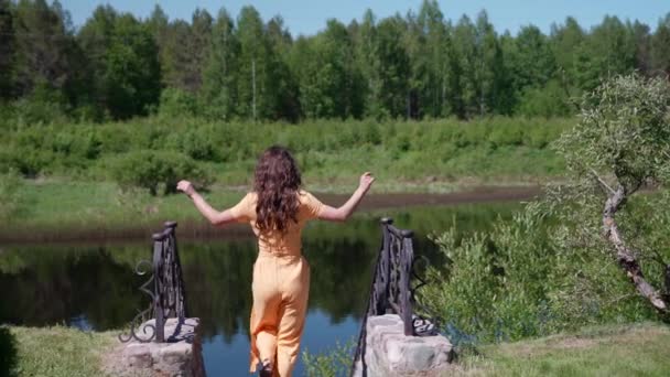 У відпустці жінка насолоджується прогулянкою на природі біля річки — стокове відео