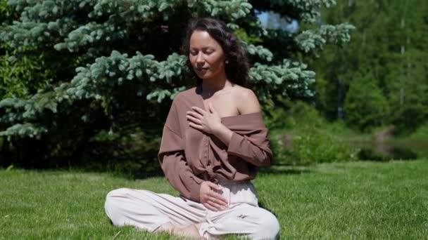 Beautiful asian woman meditates in the park during the day — Stock Video