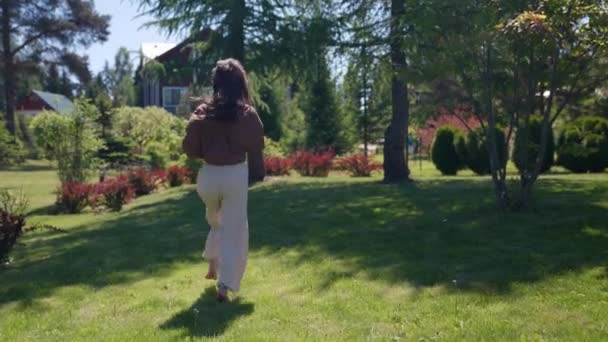 Una mujer esbelta feliz corre descalza sobre la hierba y disfruta de unas vacaciones tan esperadas — Vídeos de Stock